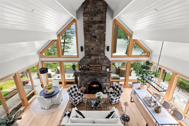 14833 Sunburst Dr, Bigfork, MT 59911 - living area with wood finished floors, healthy amount of natural light, high vaulted ceiling, and a fireplace