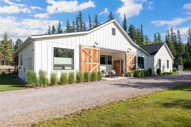 14833 Sunburst Dr, Bigfork, MT 59911 - modern farmhouse style home with board and batten siding, an outdoor structure, and driveway