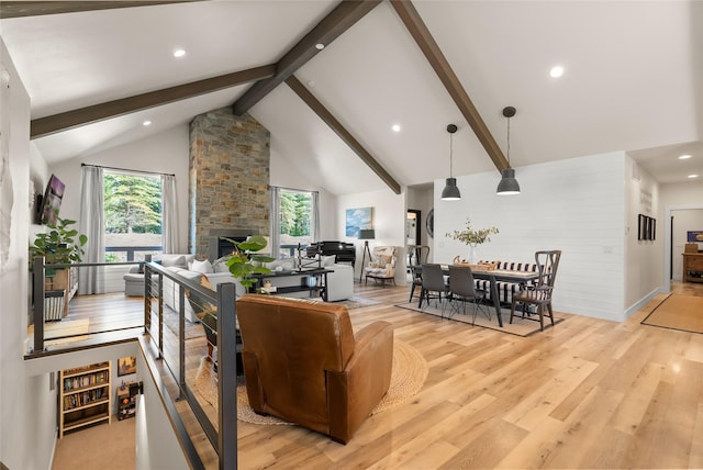 14833 Sunburst Dr, Bigfork, MT 59911 - living room featuring beamed ceiling, high vaulted ceiling, light wood-style flooring, a fireplace, and recessed lighting