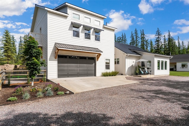 14833 Sunburst Dr, Bigfork, MT 59911 - view of front of property with driveway, a garage, board and batten siding, and a metal roof