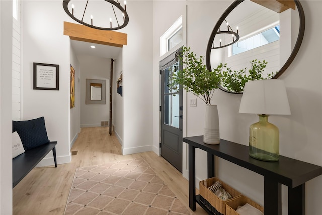 14833 Sunburst Dr, Bigfork, MT 59911 - entrance foyer featuring light wood-style floors, a chandelier, and healthy amount of natural light