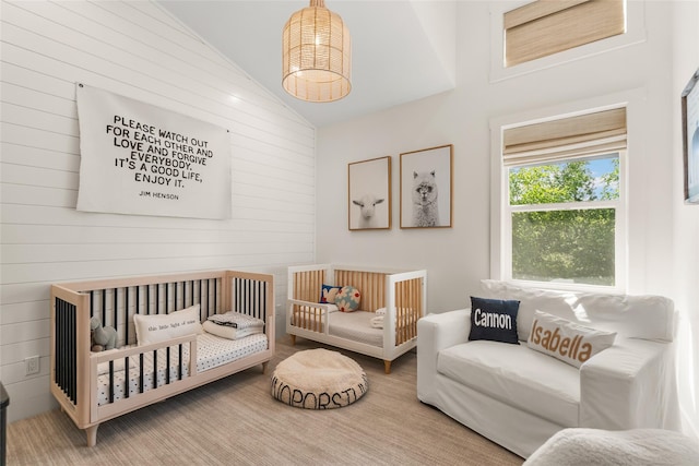 14833 Sunburst Dr, Bigfork, MT 59911 - bedroom featuring high vaulted ceiling, wood walls, and a crib