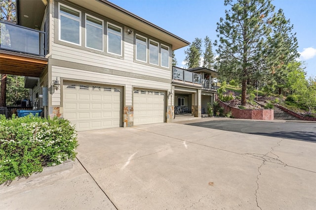 5959 Hayes Creek Rd, Missoula, MT 59804 - view of front of house with a garage, driveway, a balcony, and stone siding