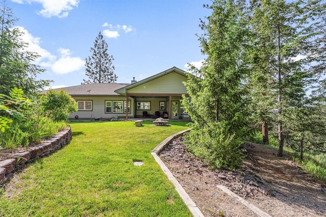 5959 Hayes Creek Rd, Missoula, MT 59804 - back of property with an outdoor fire pit, a lawn, and a patio area