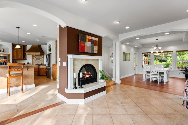 5959 Hayes Creek Rd, Missoula, MT 59804 - living room featuring a glass covered fireplace, light tile patterned floors, a chandelier, and recessed lighting