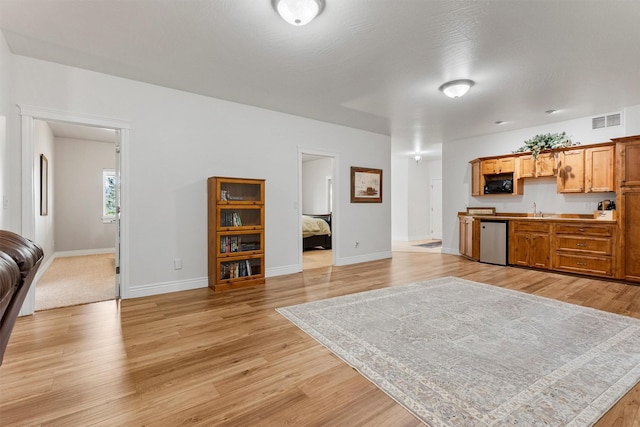 5959 Hayes Creek Rd, Missoula, MT 59804 - kitchen featuring stainless steel dishwasher, open floor plan, light wood-style floors, black microwave, and a sink