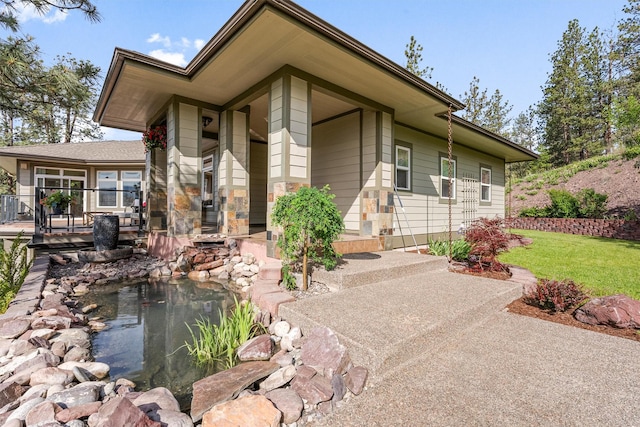 5959 Hayes Creek Rd, Missoula, MT 59804 - view of front facade with a small pond, a front lawn, and a wooden deck