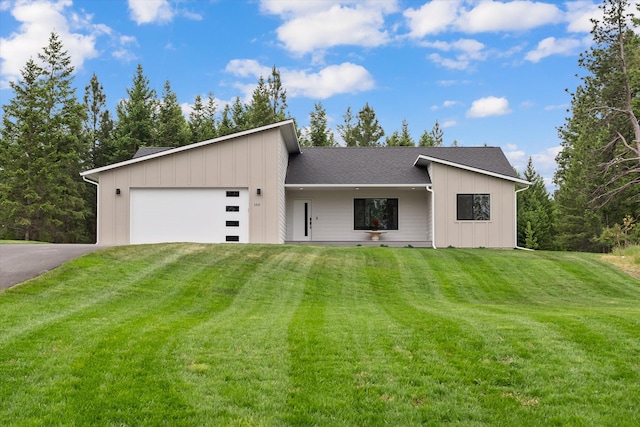100 Bench Run, Columbia Falls, MT 59912 - mid-century inspired home featuring a garage, asphalt driveway, a front lawn, and board and batten siding