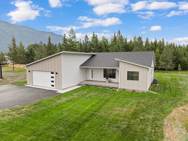 100 Bench Run, Columbia Falls, MT 59912 - view of front of house with board and batten siding, roof with shingles, cooling unit, and a front lawn