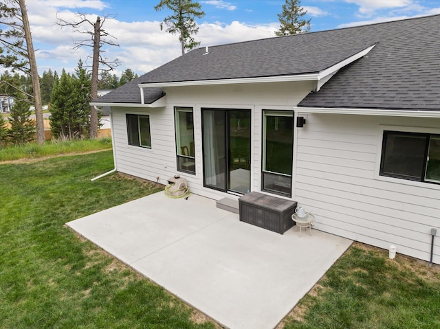 100 Bench Run, Columbia Falls, MT 59912 - rear view of property featuring a shingled roof, a patio area, and a lawn