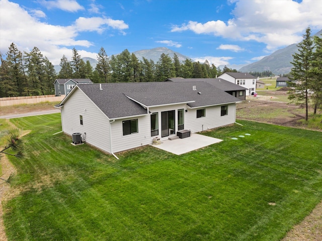 100 Bench Run, Columbia Falls, MT 59912 - rear view of house featuring a patio, roof with shingles, a mountain view, central air condition unit, and a lawn