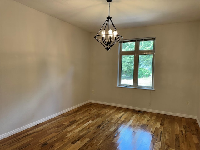 638 Trestle Creek Dr, Saint Regis, MT 59866 - empty room with wood finished floors, baseboards, and a chandelier