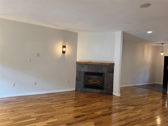 638 Trestle Creek Dr, Saint Regis, MT 59866 - unfurnished living room with wood finished floors, baseboards, and a tiled fireplace