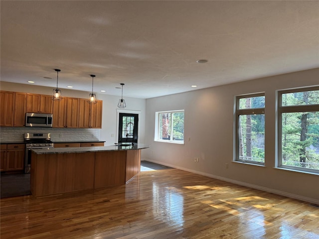 638 Trestle Creek Dr, Saint Regis, MT 59866 - kitchen featuring stainless steel appliances, baseboards, wood finished floors, decorative backsplash, and recessed lighting