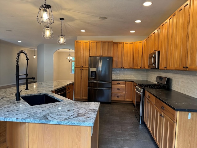 638 Trestle Creek Dr, Saint Regis, MT 59866 - kitchen with stainless steel appliances, a sink, tasteful backsplash, recessed lighting, and arched walkways