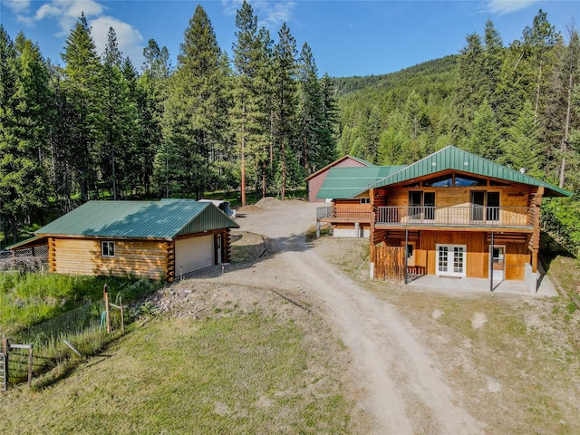104 Swede Gulch Rd, Libby, MT 59923 - log home featuring log siding, a view of trees, driveway, a deck, and metal roof