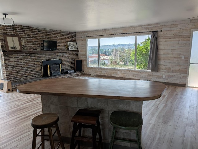 11 City Shop Rd, Shelby, MT 59474 - kitchen featuring wood finished floors, a breakfast bar area, and brick wall
