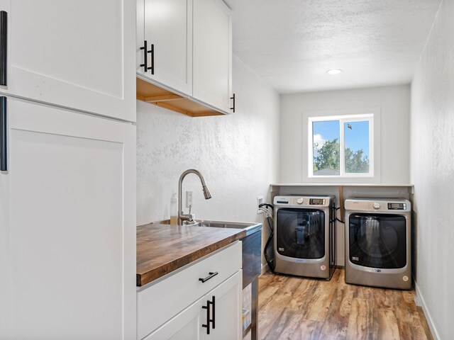 871 Conrad Dr, Kalispell, MT 59901 - laundry area featuring cabinet space, washer and clothes dryer, light wood-style floors, a textured wall, and a textured ceiling