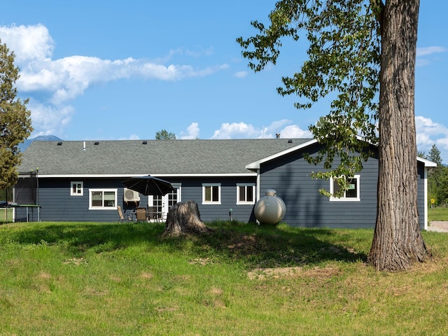 871 Conrad Dr, Kalispell, MT 59901 - back of house featuring a trampoline, a yard, and a shingled roof