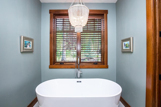 2475 E Lakeshore Dr, Whitefish, MT 59937 - bathroom featuring baseboards, a chandelier, and a freestanding bath
