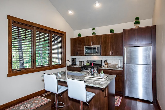 2475 E Lakeshore Dr, Whitefish, MT 59937 - kitchen featuring appliances with stainless steel finishes, lofted ceiling, dark wood-style floors, dark brown cabinets, and decorative backsplash