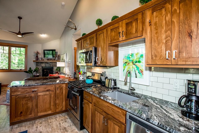 2475 E Lakeshore Dr, Whitefish, MT 59937 - kitchen with appliances with stainless steel finishes, a sink, a peninsula, brown cabinets, and vaulted ceiling