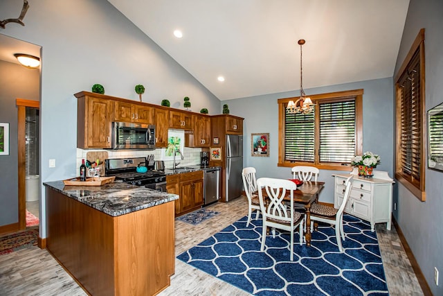 2475 E Lakeshore Dr, Whitefish, MT 59937 - kitchen with stainless steel appliances, a sink, a chandelier, light wood-style floors, and high vaulted ceiling