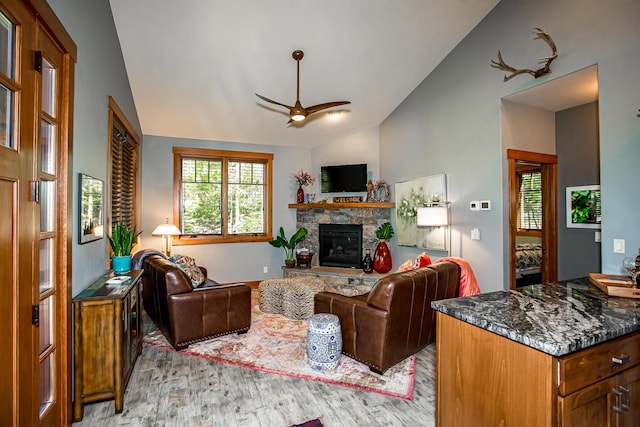 2475 E Lakeshore Dr, Whitefish, MT 59937 - living area with vaulted ceiling, ceiling fan, light wood-style flooring, and a stone fireplace