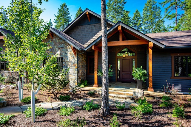2475 E Lakeshore Dr, Whitefish, MT 59937 - craftsman house with stone siding, a porch, and a shingled roof