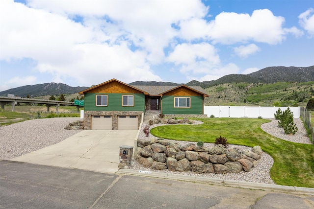 116 Windameer Ct, Butte, MT 59701 - view of front facade with stone siding, concrete driveway, a mountain view, and an attached garage
