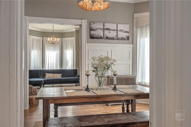 902 N Park Ave, Helena, MT 59601 - dining space featuring crown molding, a chandelier, wood finished floors, a wainscoted wall, and a decorative wall