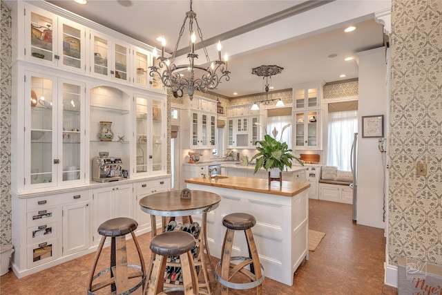 902 N Park Ave, Helena, MT 59601 - kitchen with a kitchen island, freestanding refrigerator, white cabinetry, hanging light fixtures, and wooden counters