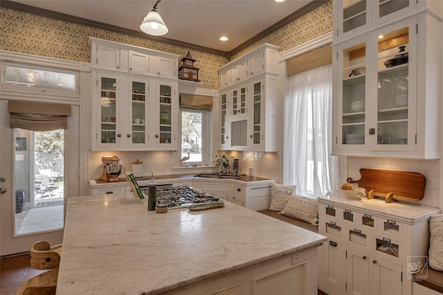 902 N Park Ave, Helena, MT 59601 - kitchen with white cabinetry, stainless steel gas cooktop, wallpapered walls, a sink, and light stone countertops