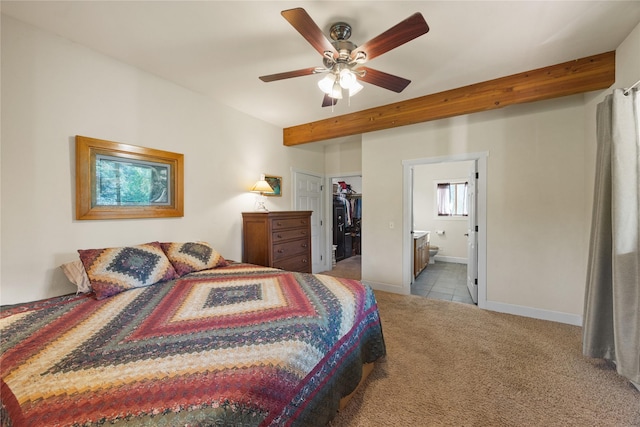 13471 Sundance Trl, Bigfork, MT 59911 - carpeted bedroom featuring a walk in closet, ensuite bathroom, beamed ceiling, ceiling fan, and tile patterned flooring