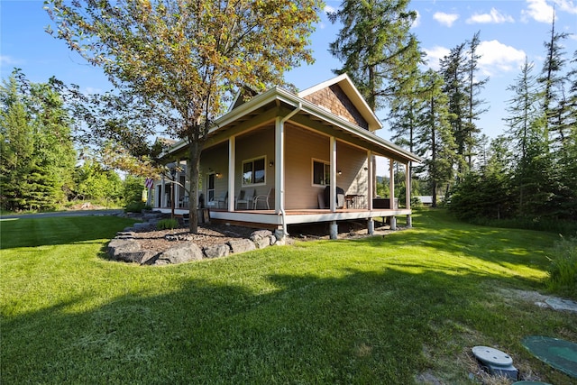 13471 Sundance Trl, Bigfork, MT 59911 - back of house featuring a yard and covered porch
