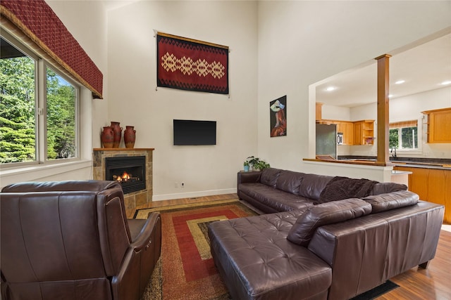 13471 Sundance Trl, Bigfork, MT 59911 - living area with wood finished floors, a towering ceiling, and a tiled fireplace