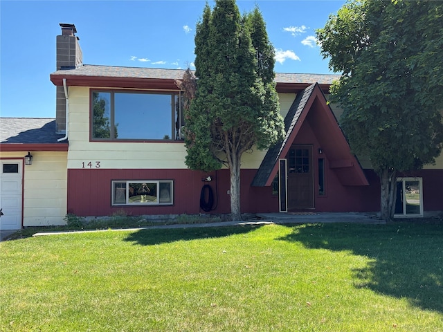 143 Anns Ln, Lolo, MT 59847 - rear view of house featuring a chimney, a yard, and a shingled roof