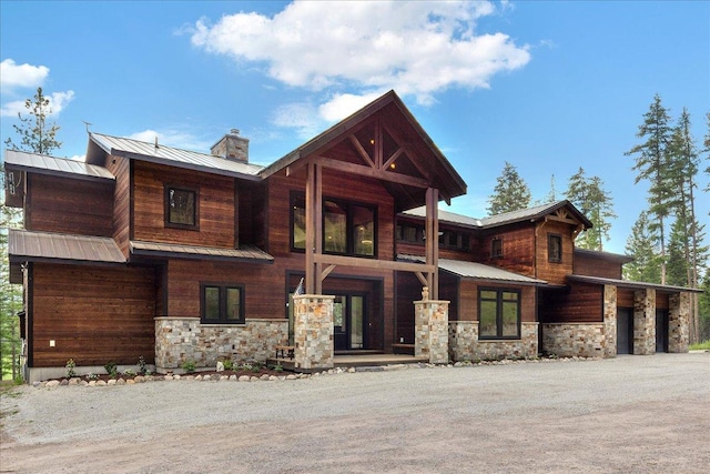 1929 Km Ranch Rd, Whitefish, MT 59937 - view of front of home featuring stone siding, a chimney, and metal roof