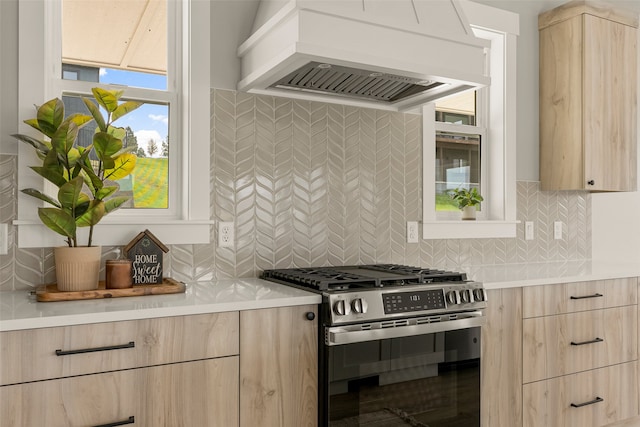 7018 Max Dr, Missoula, MT 59803 - kitchen with custom exhaust hood, stainless steel gas range oven, light brown cabinets, and modern cabinets
