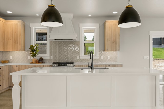 7018 Max Dr, Missoula, MT 59803 - kitchen with a sink, premium range hood, light brown cabinets, stainless steel range, and light countertops