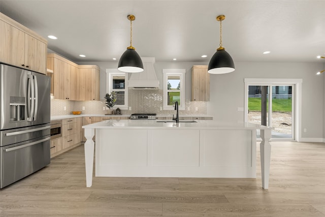 7018 Max Dr, Missoula, MT 59803 - kitchen with light brown cabinets, appliances with stainless steel finishes, custom exhaust hood, a sink, and recessed lighting