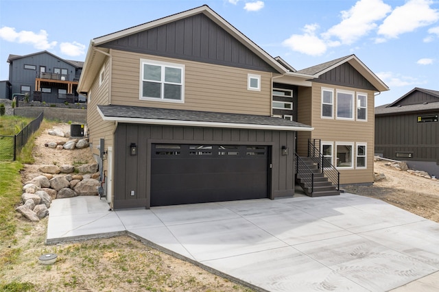 7018 Max Dr, Missoula, MT 59803 - view of front of house featuring board and batten siding, a garage, concrete driveway, central air condition unit, and roof with shingles