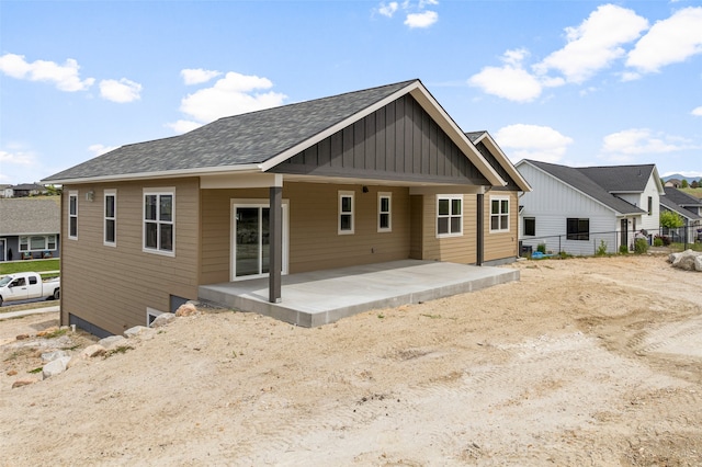 7018 Max Dr, Missoula, MT 59803 - back of property with board and batten siding, a patio area, and roof with shingles