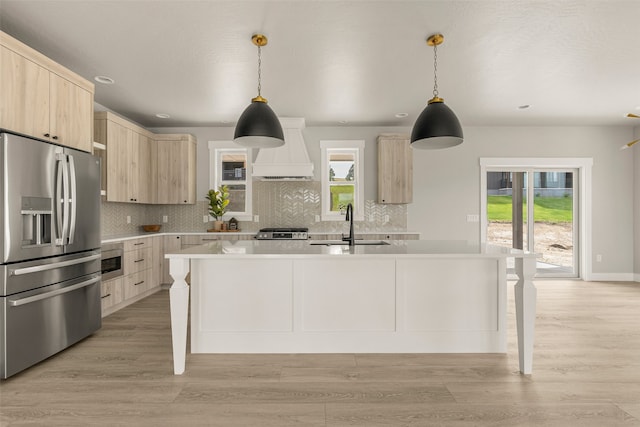 7018 Max Dr, Missoula, MT 59803 - kitchen featuring light brown cabinets, appliances with stainless steel finishes, custom range hood, light countertops, and modern cabinets