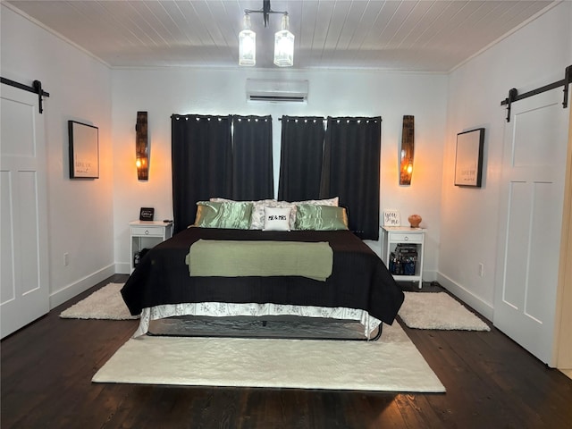 411 10th Ave NE, Choteau, MT 59422 - bedroom featuring a barn door, crown molding, a wall mounted air conditioner, dark wood-style floors, and baseboards