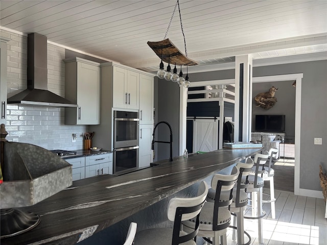 411 10th Ave NE, Choteau, MT 59422 - kitchen featuring wall chimney exhaust hood, dark countertops, double oven, tasteful backsplash, and a kitchen breakfast bar