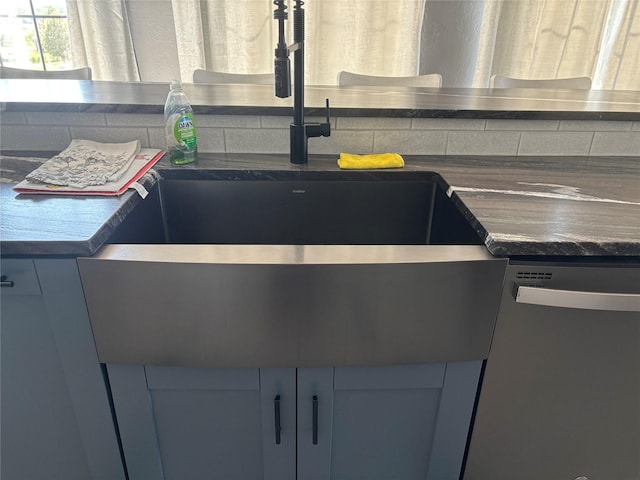 411 10th Ave NE, Choteau, MT 59422 - kitchen view of stainless steel dishwasher, dark countertops, and a sink