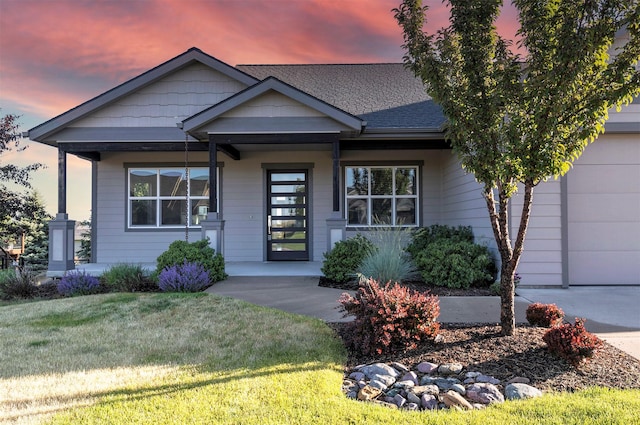 4995 Jeff Dr, Missoula, MT 59803 - view of front of home featuring covered porch, a front lawn, a shingled roof, and a garage