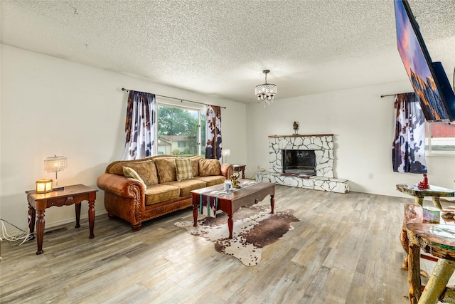5900 Longview Dr, Missoula, MT 59803 - living area with a textured ceiling, wood finished floors, a stone fireplace, and a chandelier