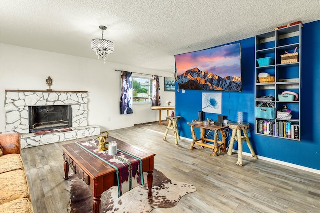 5900 Longview Dr, Missoula, MT 59803 - living area with wood finished floors, a textured ceiling, a stone fireplace, a chandelier, and baseboards